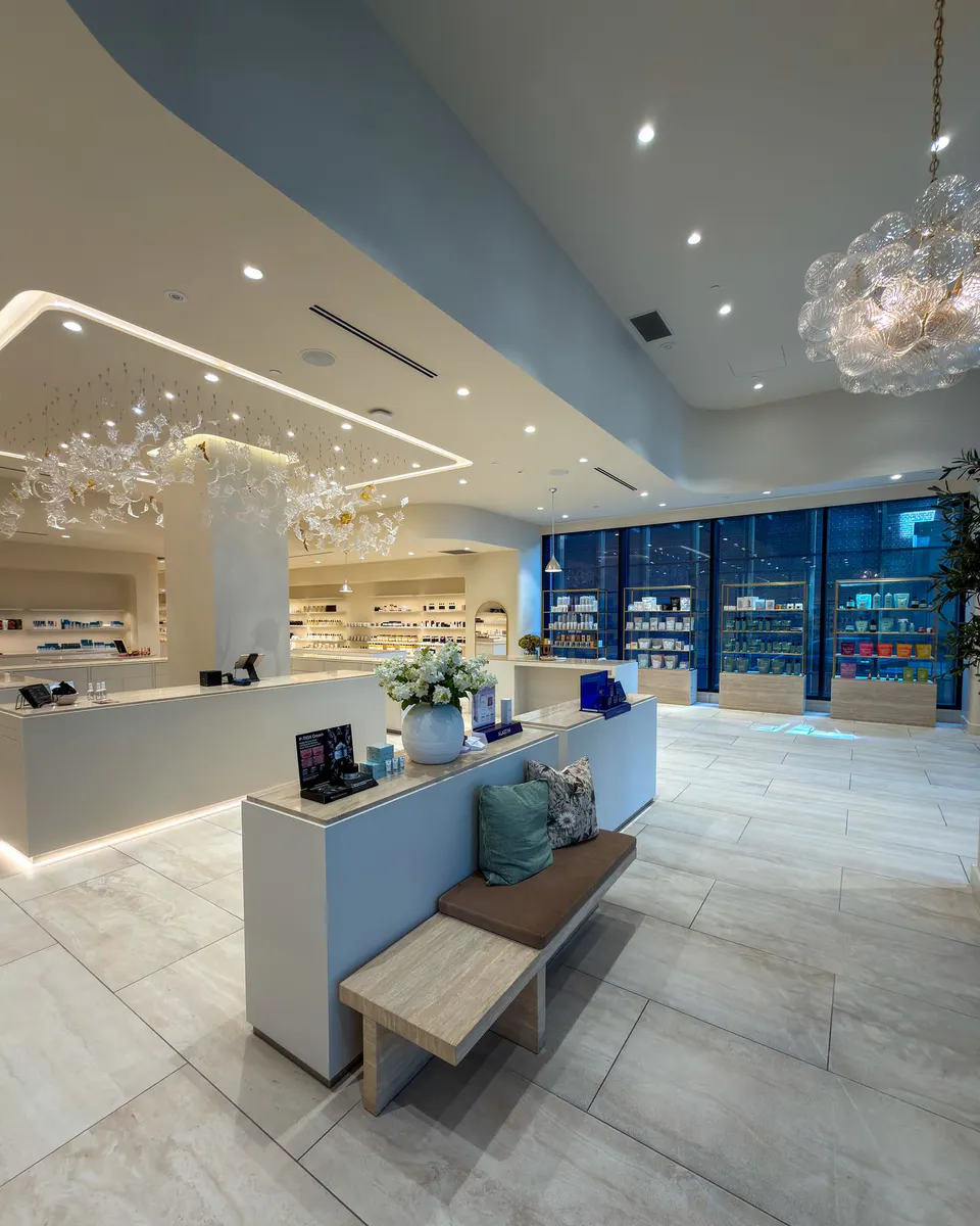 A wide view of the Skin Vault at The Well boutique showroom with illuminated displays and seating